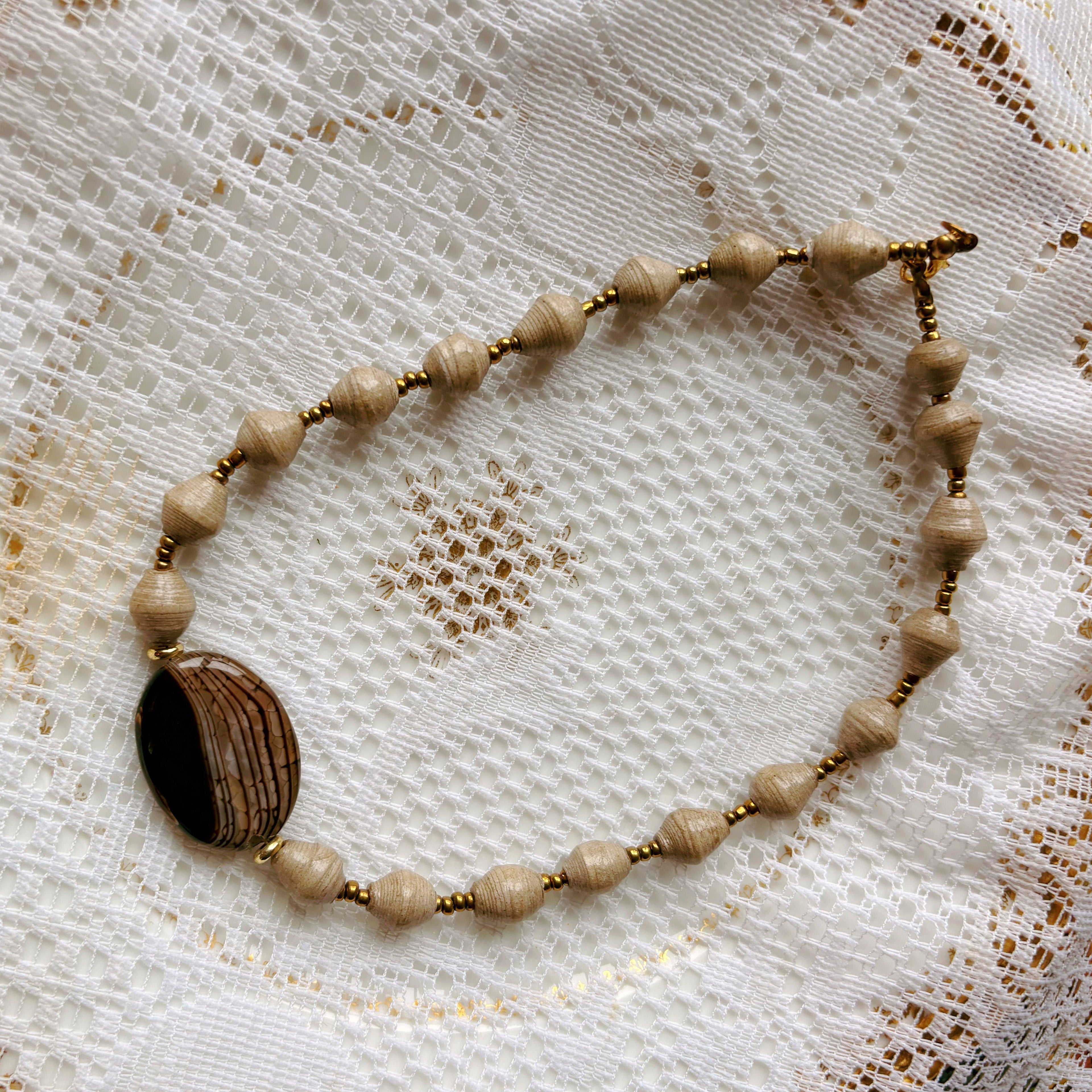 Necklace with a large brown bead on a lace background