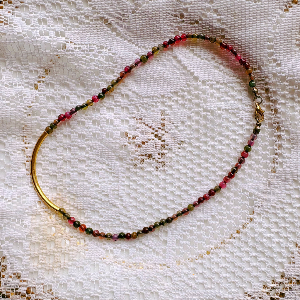 Necklace with multicolored beads on a lace fabric background