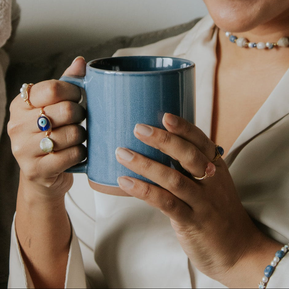 Woman holding a blue mug with a neutral background
