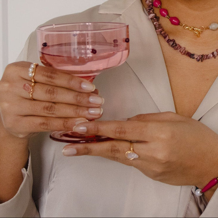 Woman holding a glass of pink wine against a white background