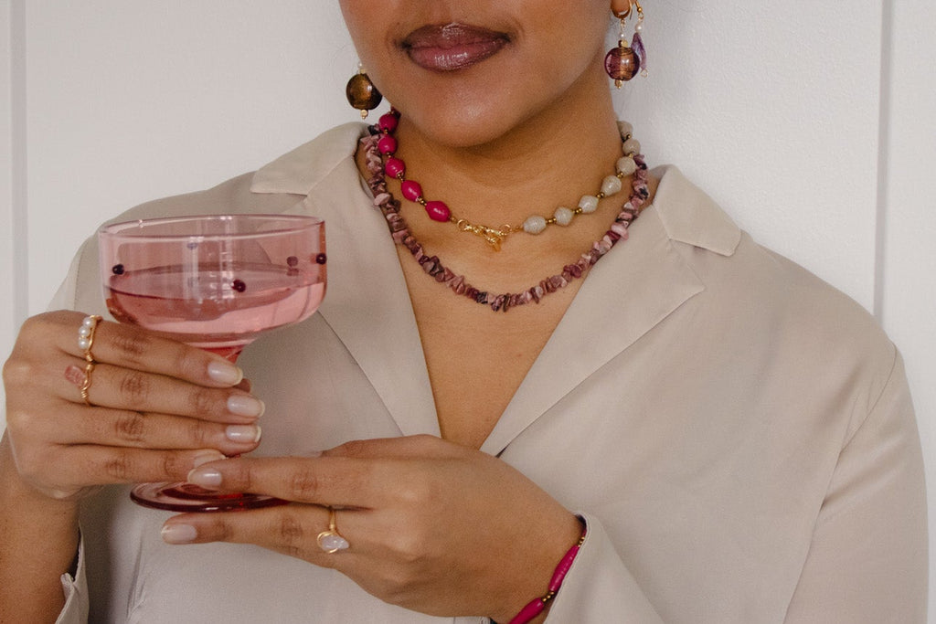 Woman holding a glass of pink wine against a white background