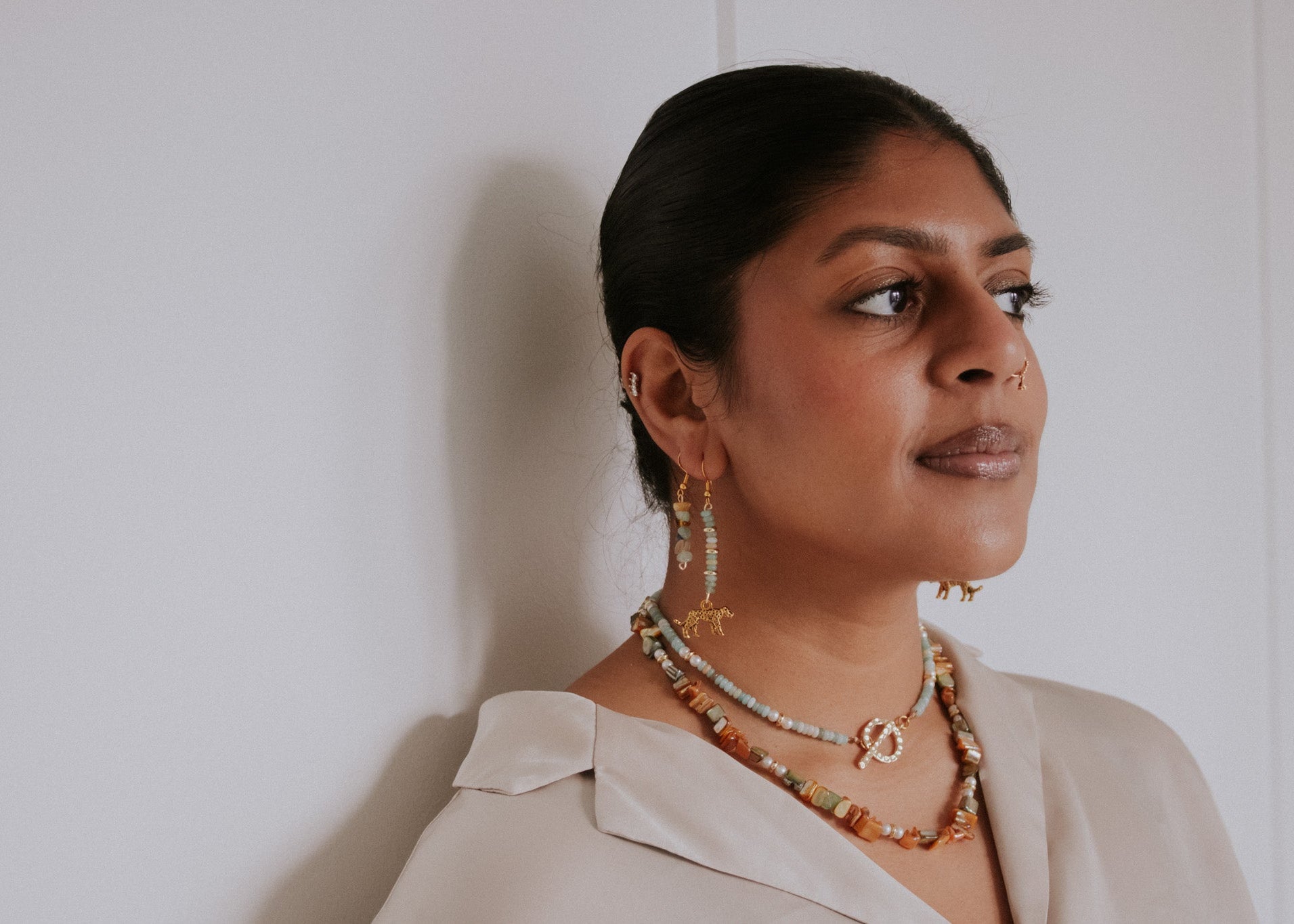 Woman wearing jewelry against a plain background