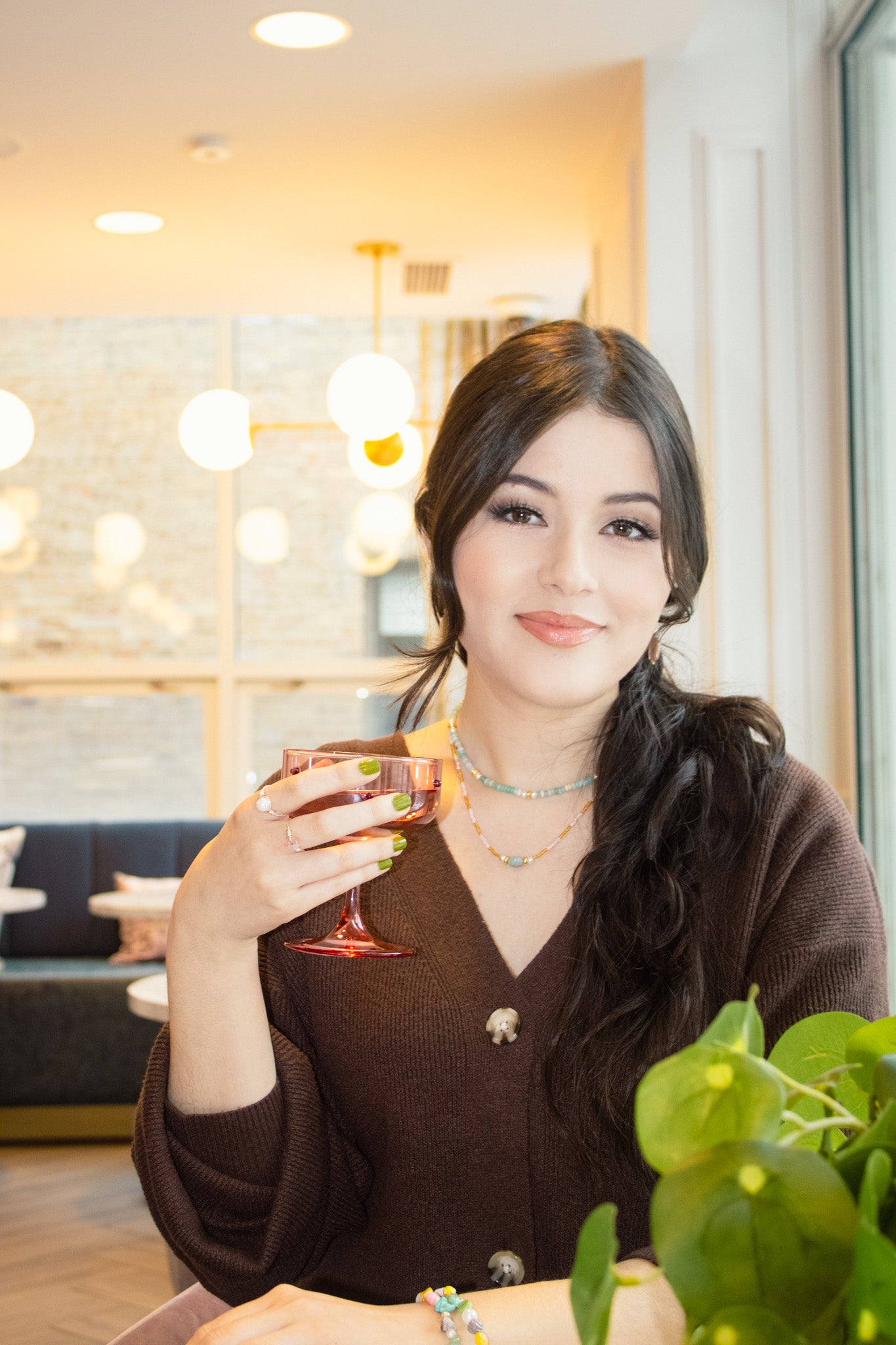 Woman holding a glass of red wine in an indoor setting