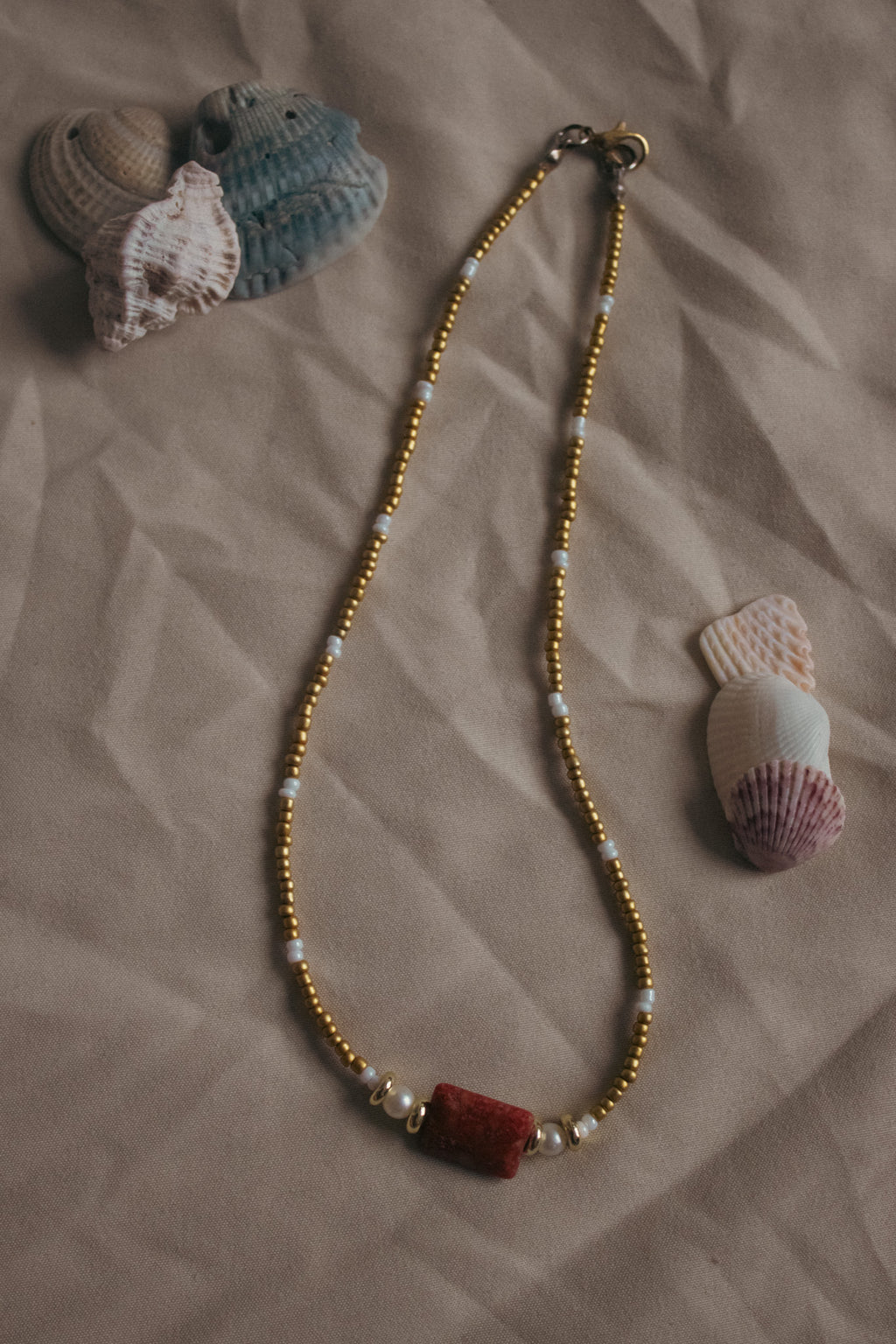 Beaded necklace with natural elements on a textured surface