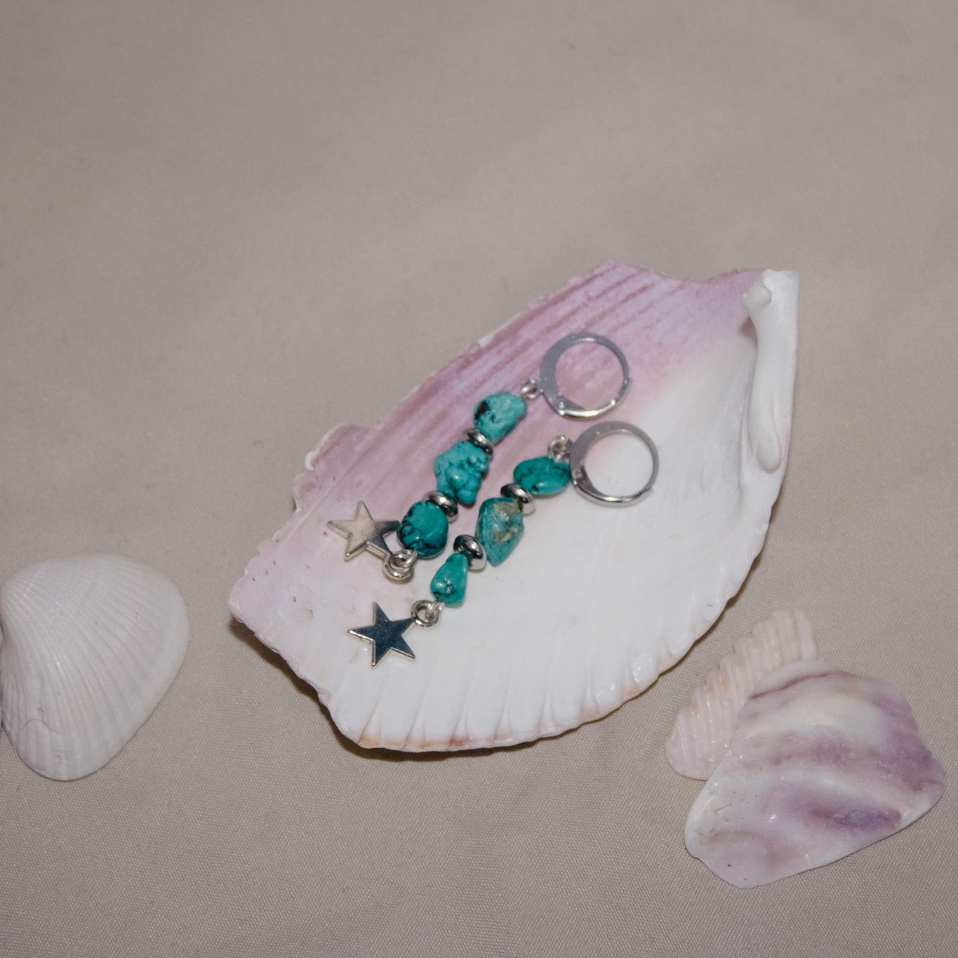 Shell with decorative keychain and small shells on a beige surface